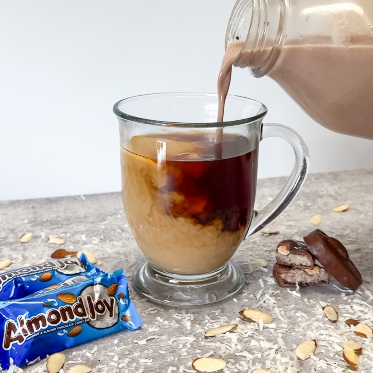 pouring almond joy coffee creamer into coffee
