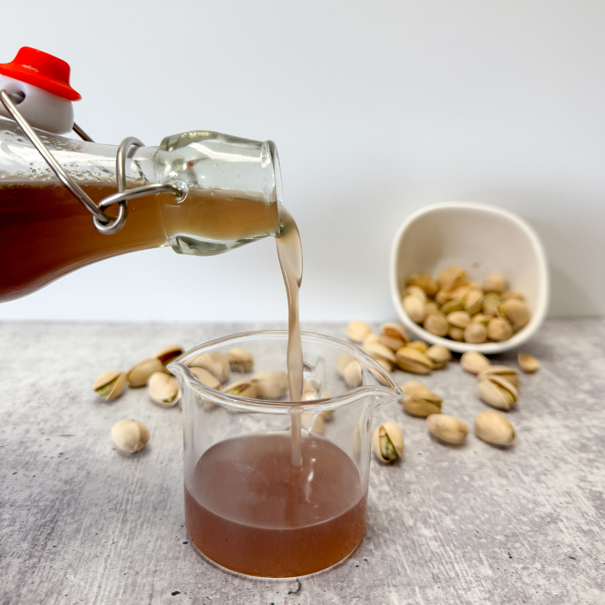 pouring pistachio syrup into a small glass
