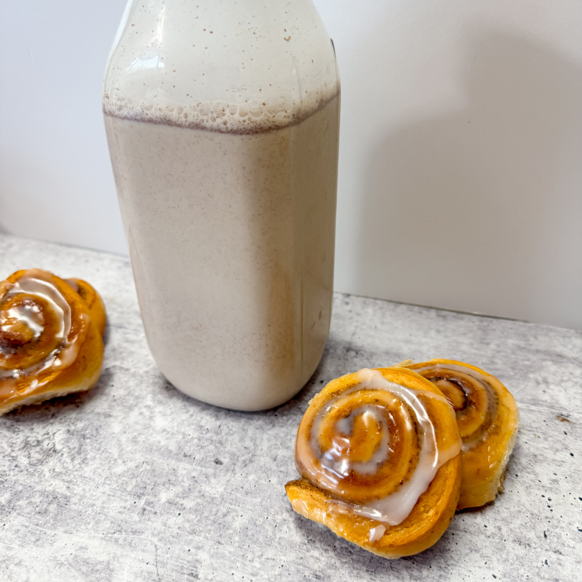 close up of cinnamon rolls with a jar of coffee creamer in the background