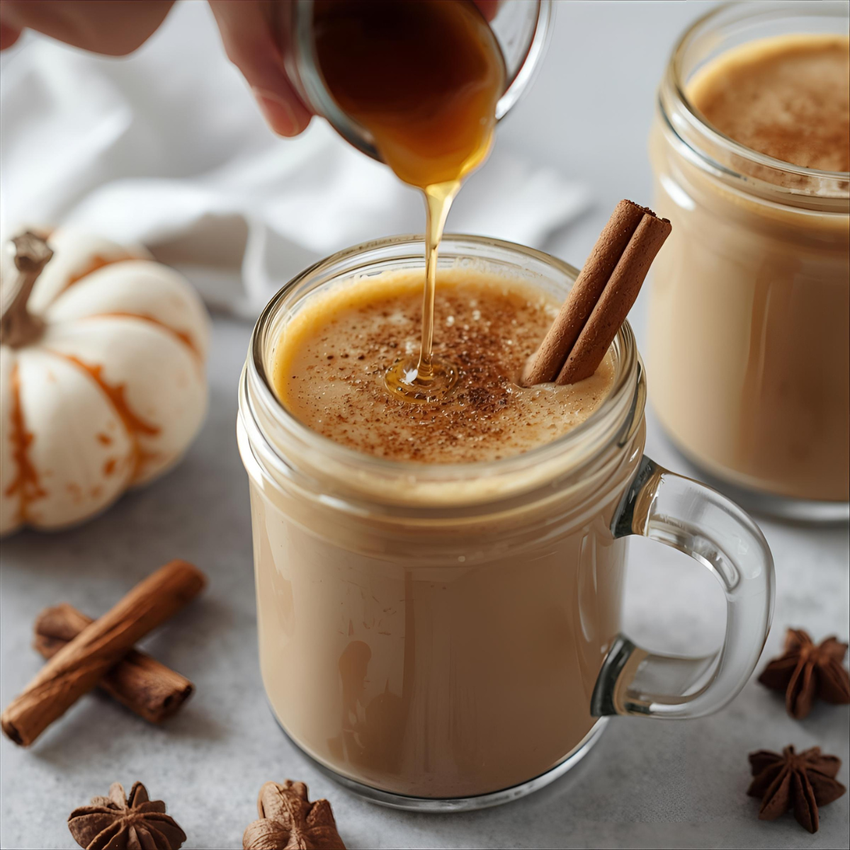 pumpkin coffee syrup being poured into a latte