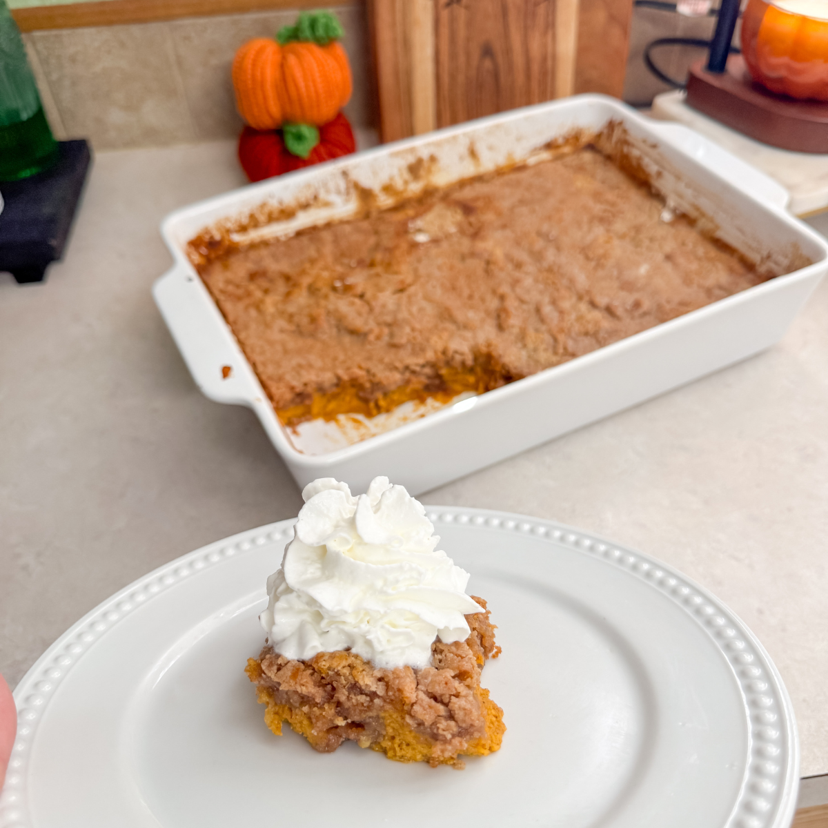 pumpkin dump cake on a plate with whipped cream